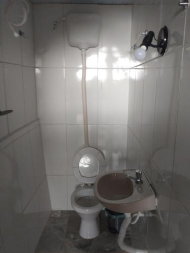 a small bathroom with a toilet and a sink at quarto 3 pra 4 pessoas in Ouro Preto