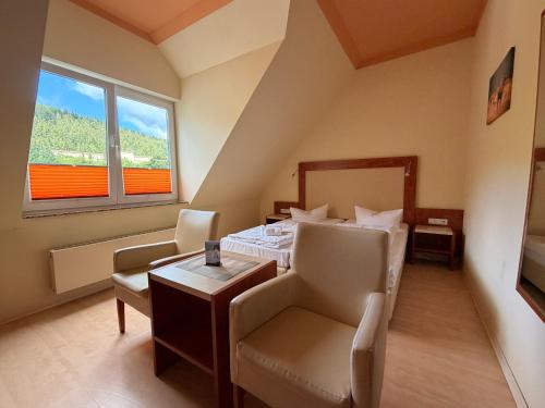 a bedroom with a bed and a table and chairs at Alte Schleiferei in Breitenbrunn