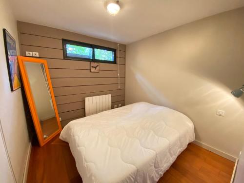 a small bedroom with a white bed and a window at BELLEVUE Maison Atypique Grande Terrasse au Calme in Pyla-sur-Mer
