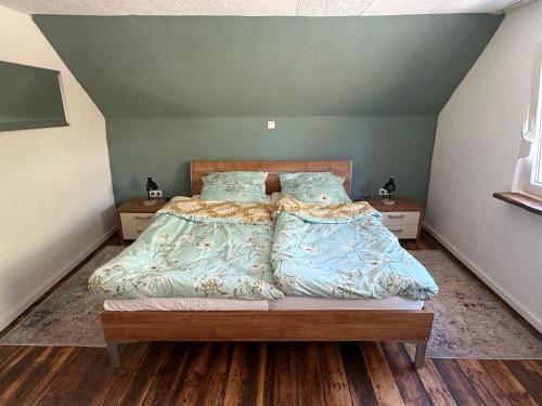 a bedroom with a bed with blue comforter and pillows at Ferienhaus Weitblick in Oberthal