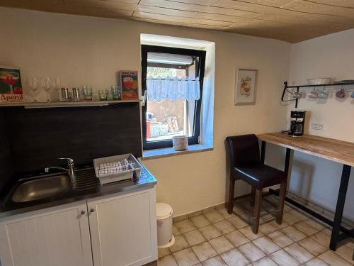 a kitchen with a sink and a counter with a chair at Ferienhaus Weitblick in Oberthal