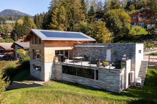 a house with solar panels on the roof at Villa moderne avec Jacuzzi - ski - golf in Icogne