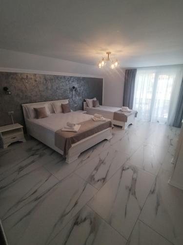 two beds in a large room with marble floors at Vila Cristal in Arefu