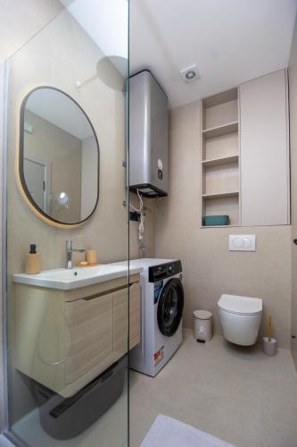 a bathroom with a sink and a washing machine at Lastva Cozy apartment in Prijevor