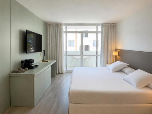 a bedroom with a large white bed and a window at Prinsotel Alba & Spa in Cala d´Or
