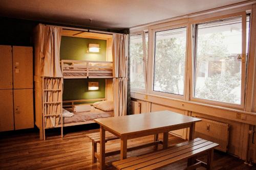 a room with a bunk bed and a table at Wombat's City Hostel Munich Hauptbahnhof in Munich