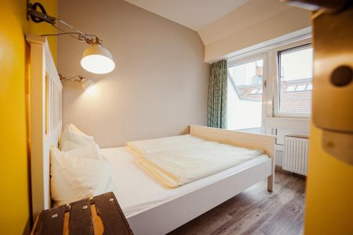 a small bed in a room with a window at Wombat's City Hostel Munich Hauptbahnhof in Munich