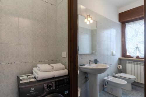 a bathroom with a sink and a toilet and a mirror at Turin Airport apt B in Leinì
