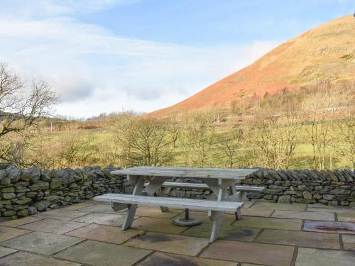 a picnic table in front of a stone wall at River View Cottage-Uk42226 in Low Borrowbridge
