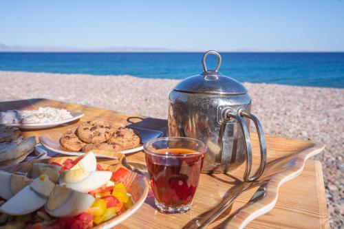 a table with food and a tea pot on the beach at Eden Camp Abu Galum in Dahab