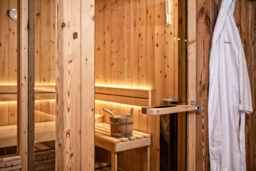 a sauna with a bucket in a wooden wall at Interest Vitalhotel - Partnerbetrieb von Oberstaufen PLUS in Oberstaufen