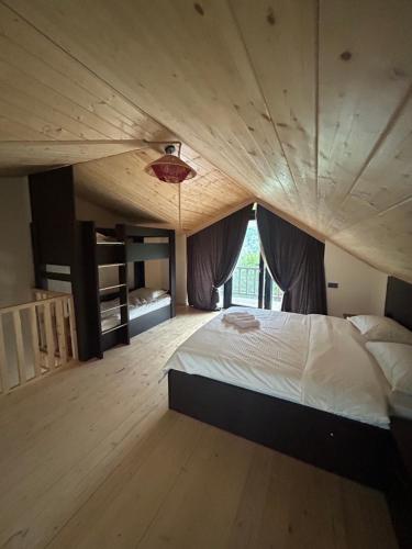 a bedroom with a large bed with a wooden ceiling at Forest Edge in Borjomi
