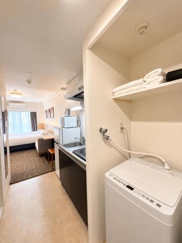 a small kitchen with a washing machine in a room at Hotel Arashi Nippombashi 1 No006 in Osaka