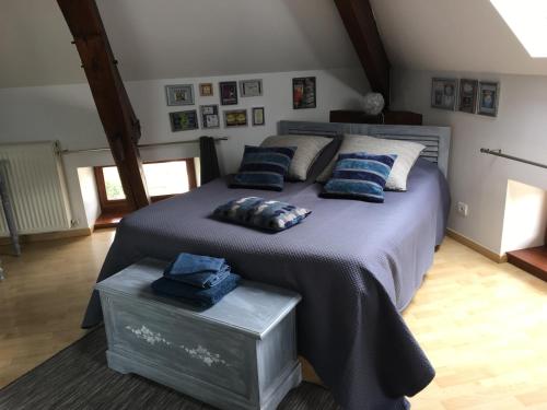 a bedroom with a large bed with blue pillows at Chambres d'hôtes Arcelot in Arceau