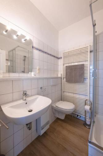 a white bathroom with a sink and a toilet at FeWo-Zingst in Prerow