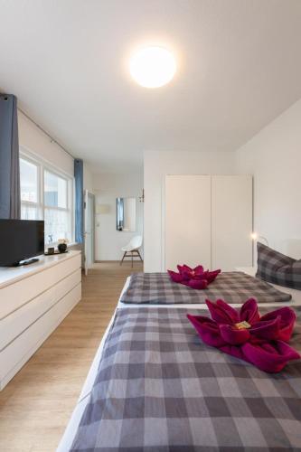 a bedroom with a large bed with red flowers on it at FeWo-Zingst in Prerow
