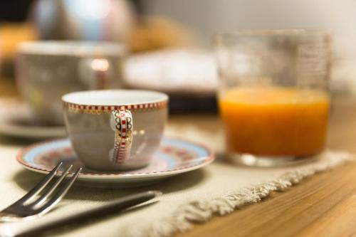 a cup and a plate on a table with a glass of orange juice at Il Duomo Luxury Suite in Pietrasanta