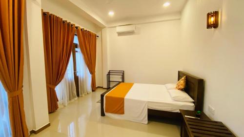 a bedroom with a bed and a large window at Harbour Front Villa in Trincomalee