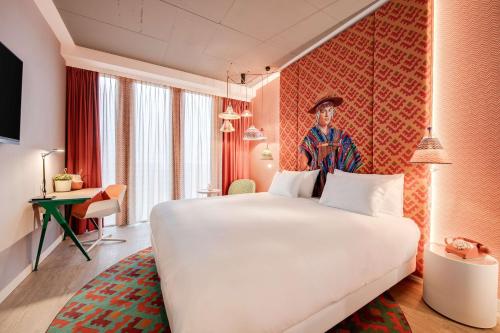 a bedroom with a large white bed in a room at nhow Amsterdam Rai in Amsterdam