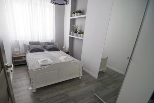 ワルシャワにあるBright Apartment Hozaのベッドルーム(白いベッド1台、鏡付)