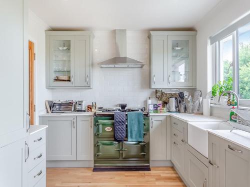 a kitchen with white cabinets and a green oven at Beautiful Highland Sanctuary in Embo