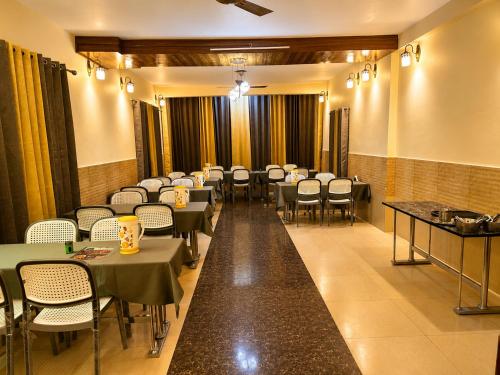 a dining room with tables and chairs in a room at Hotel Hill Top Palace in Lansdowne