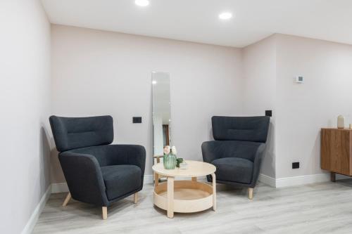 two chairs and a table in a room at Easylife - Como Villa Sofia Apartments in Como