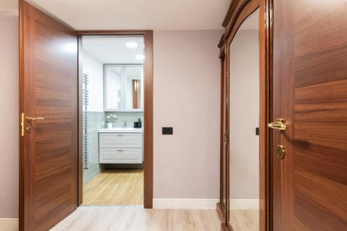a hallway with a wooden door and a bathroom at Easylife - Como Villa Sofia Apartments in Como