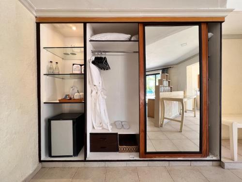 a room with a large glass cabinet with a mirror at Diani Reef Beach Resort & Spa - Your Beachfront Bliss Awaits in Diani Beach