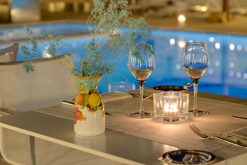 a table with two glasses of wine and a vase at Hotel Villa Blu Capri in Anacapri