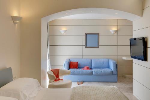 a living room with a blue couch and a tv at Hotel Villa Blu Capri in Anacapri