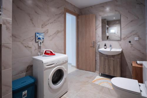 a bathroom with a washing machine and a sink at Eleonas Home Rental in Mirodháton