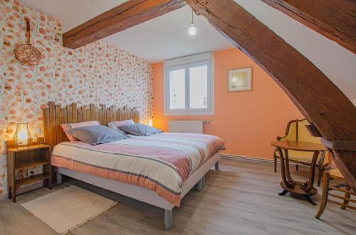 a bedroom with orange walls and a bed with a desk at Le four de mimile in Montieramey
