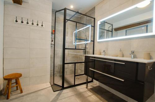 a bathroom with a glass shower and a sink at Le four de mimile in Montieramey