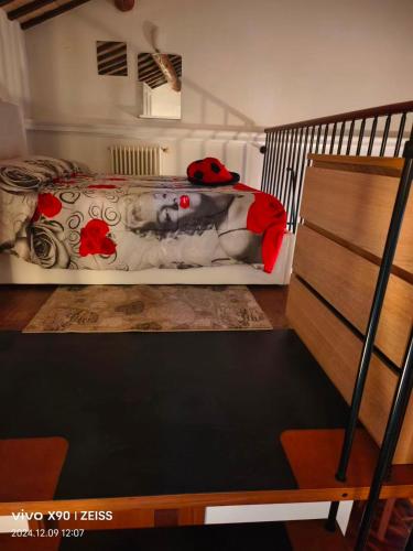 a bedroom with a bed with red flowers on it at Dimora RAVENNA CORTE CHARME Diaz in Ravenna