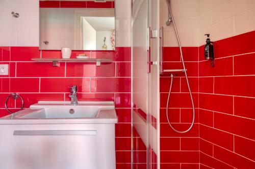 a red bathroom with a sink and a shower at Le Bretagne - Hôtel de charme labellisé Cosy Places in Vannes