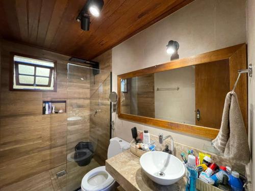 a bathroom with a sink and a toilet and a mirror at Casa Cacau - Guest house a 700m metros de geriba in Armacao dos Buzios