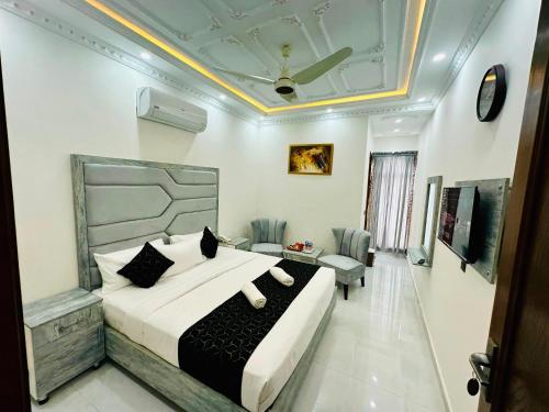a bedroom with a bed and a couch and a table at Hotel Haven Lahore in Lahore