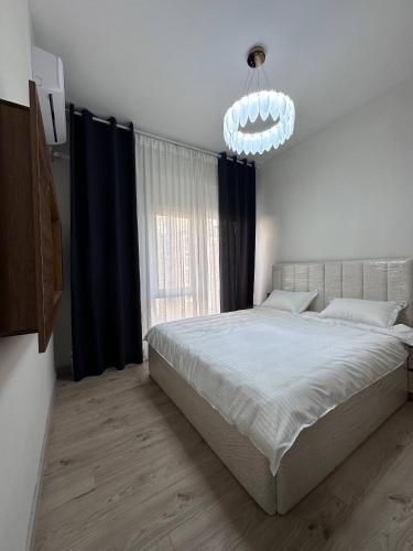 a bedroom with a large bed and a chandelier at Chorvoq Darvozasi touristic complex in Chorwoq