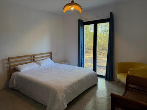 a bedroom with a bed and a sliding glass door at Can Jondalet in Sant Josep