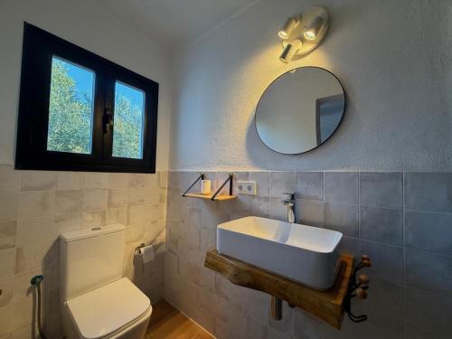 a bathroom with a sink and a toilet and a mirror at Can Jondalet in Sant Josep