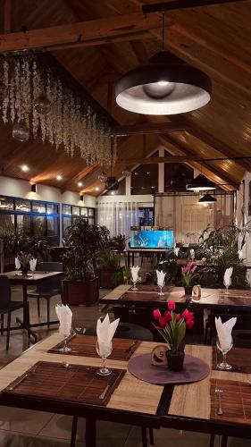 a restaurant with wooden tables and a large ceiling at Au Mirandav Hotel in Ambohidratrimo