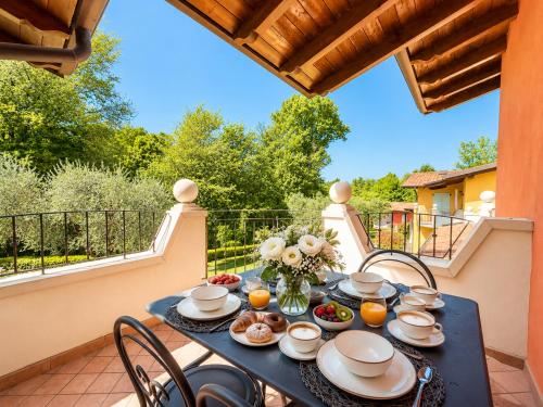 a table on a balcony with food on it at Golf 1 - Manerba del Garda in Polpenazze del Garda
