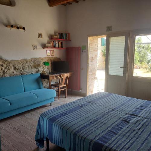 a bedroom with a bed and a desk and a couch at la cana dolce in Bertinoro
