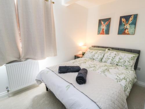 a bedroom with a bed with a black towel on it at Cern-Wyn in Chippenham