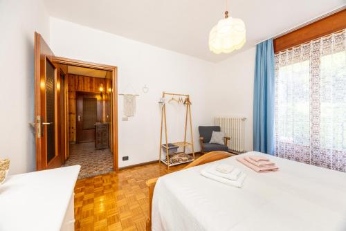 a bedroom with a white bed and a window at Casa Lena in Colorina