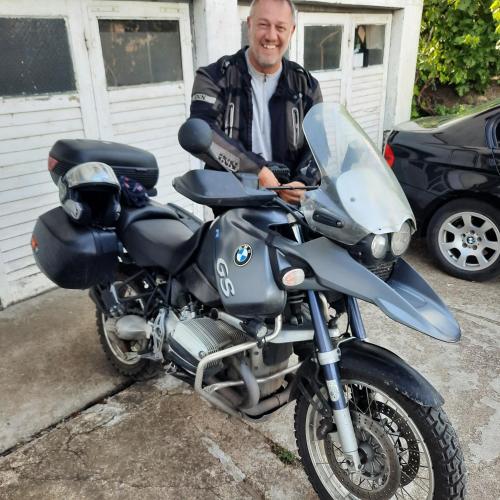 a man is standing next to a motorcycle at AGAPE in Leskovac