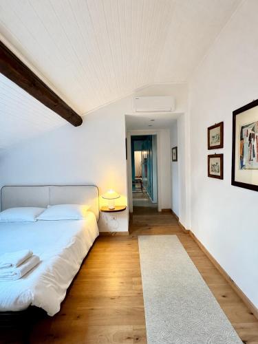 a white bedroom with a bed and a rug at Casa Il Nido Bright Rooftop Nest in Lecco
