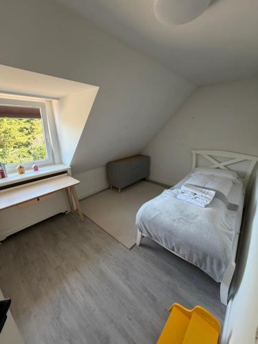 ein kleines Schlafzimmer mit einem Bett und einem Fenster in der Unterkunft Syltfisch in Sylt