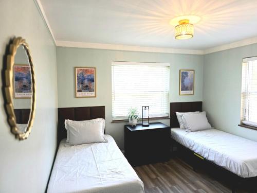 a bedroom with two beds and a mirror at 513Company - Sanctuary in Cincinnati